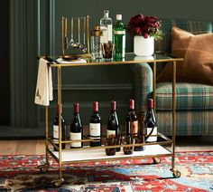 a bar cart filled with bottles of wine on top of a rug