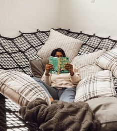 a woman laying in bed reading a book