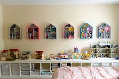 there are many toy houses on the wall above the bed in this child's room