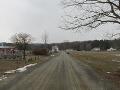 an empty dirt road in the middle of a cemetery