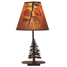 a table lamp with pine cones on the base and a brown lampshade over it