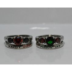 two rings with different colored stones are on a white surface and one has the word harry potter written on it