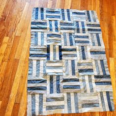 a blue and white patchwork rug sitting on top of a wooden floor next to a hard wood floor