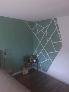 a room with green walls and white lines painted on the wall, along with potted plants