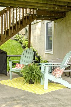 two lawn chairs sitting on top of a patio next to a table and potted plant