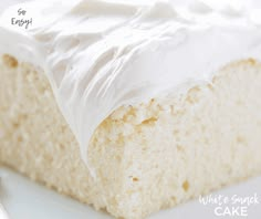 a piece of cake with white frosting sitting on a plate