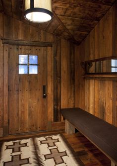 a room with wood paneling and a bench