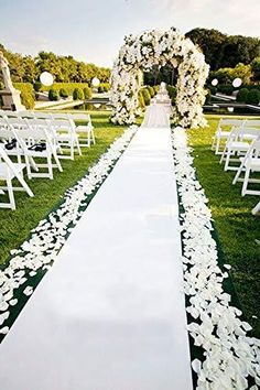 the aisle is lined with white flowers and petals