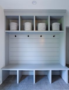 a white bench with baskets on it in a room