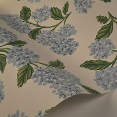 a blue and green flowered wallpaper with leaves on it's back side