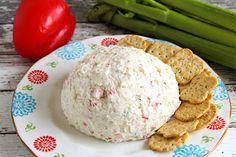 a cheese ball and crackers on a plate with asparagus next to it