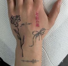 a woman's hand with a flower and chinese writing on the left side of her wrist