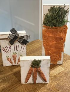 three carrots painted on wood blocks sitting on a table