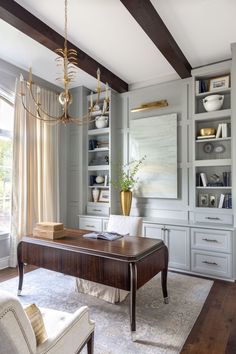 an elegant office with built in bookcases and desk