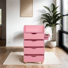 a pink dresser sitting on top of a wooden floor next to a potted plant