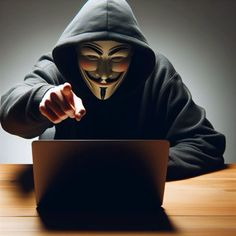 a person wearing a mask and using a laptop on a wooden table in the dark