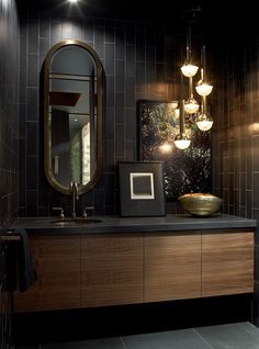 a bathroom with a sink, mirror and lights on the wall in front of it