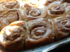 cinnamon rolls with icing in a glass baking dish