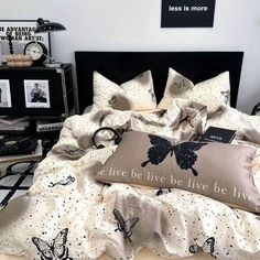 there is a bed with butterflies on it and a pillow that says live love live