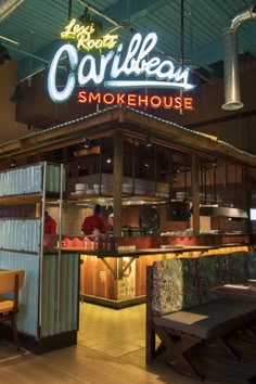 the inside of a restaurant with neon signs above it's counter and seating area