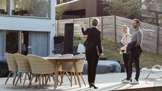 two people standing on a deck with chairs