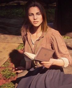 a woman sitting on the ground holding an open book