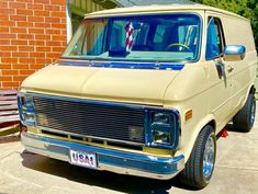 an old van parked in front of a brick building