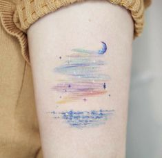 a person with a tattoo on their arm that has the sky and stars painted on it