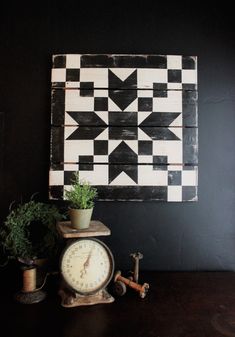 a clock sitting on top of a wooden table next to a potted plant and other items