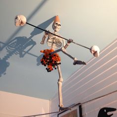 a fake skeleton is hanging from the ceiling with decorations on it's head and arms