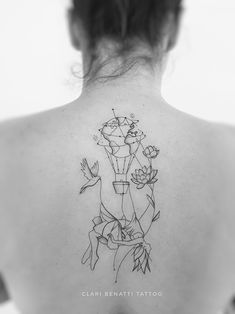 the back of a woman's neck with tattoos on her body and flowers in it