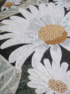 white and brown flowers are on the floor in this mosaic style tile design with gold centers