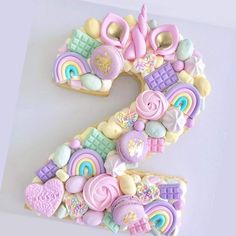 the number two made out of cookies is decorated with rainbows and other sweets on it