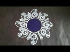 a white and blue circular design on a black table cloth with swirls in the center