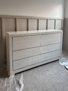 a white dresser sitting in the middle of a room