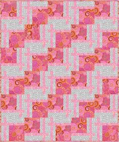 a pink and white quilt with an orange flower design on the center, in front of a