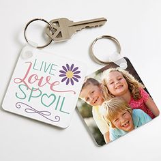 a couple of key chains sitting on top of a white table next to a photo