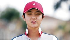 a young man wearing a red and white baseball cap, looking off to the side