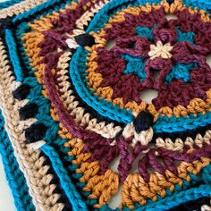 a crocheted square is shown in multicolors