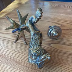 a metal figurine sitting on top of a wooden table next to a star