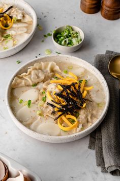 two white bowls filled with food on top of a table