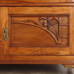 an old wooden cabinet with carvings on the front and side panels, inlaid with metal handles