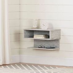 a shelf with books and glasses on it in a room next to a wall mounted clock