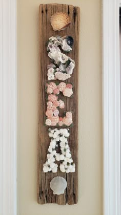 a wooden sign with shells and seashells on it