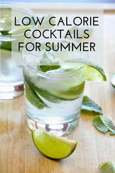 two glasses filled with water and limes on top of a wooden table