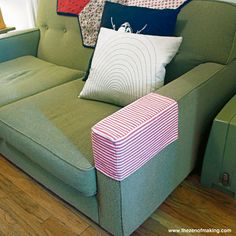 a green couch with several pillows on it