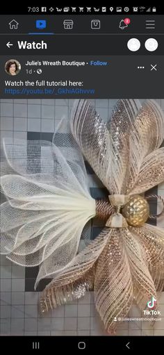 an image of a flower made out of mesh and gold beads on a cell phone screen