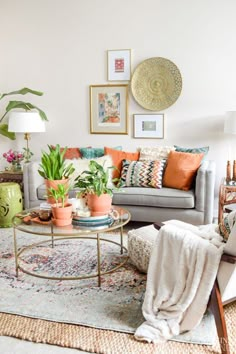 a living room filled with lots of furniture and plants on top of a coffee table