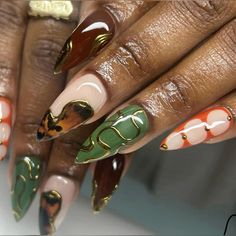 a woman's hands with colorful manies and gold decorations on their nails,