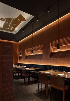 a dimly lit restaurant with wooden booths and black leather seats on either side of the tables